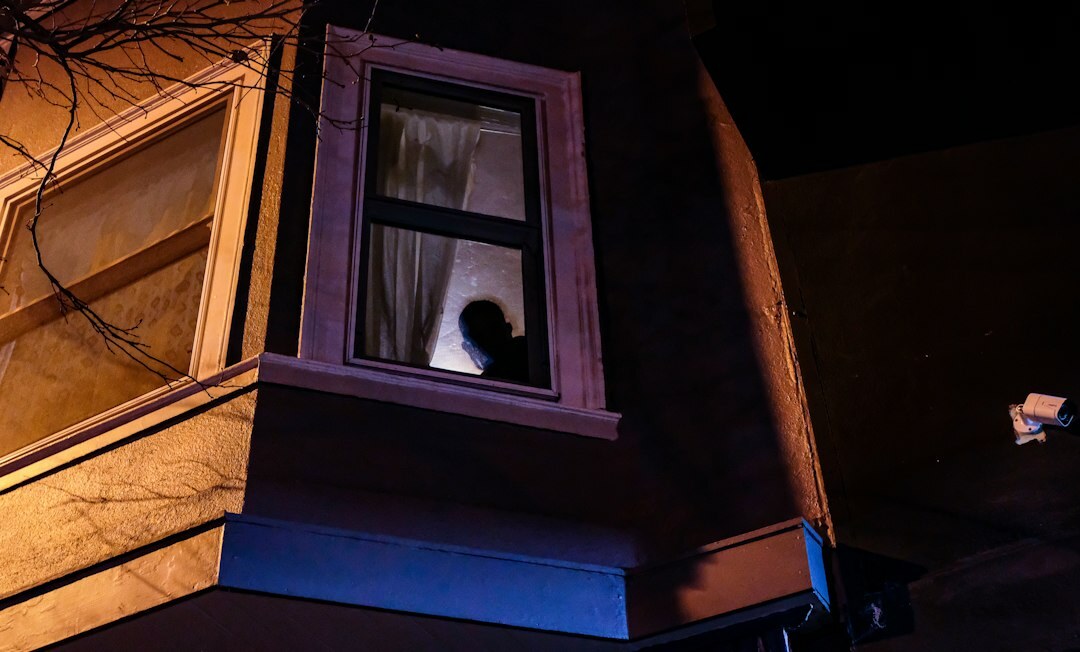 person looking out window at night